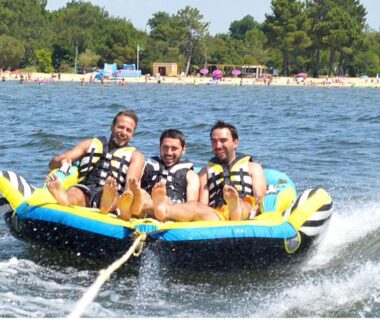 Lac avec trois hommes sur bouée tractée aux Bungalows mh732 3ch ou mh828 4ch Biscarrosse Lake