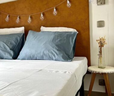 Chambre avec lits et tête de lit à guirlande lumineuse au Camping Gallina Varja