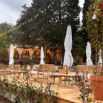 Terrasse en bois avec tables et parasols au camping Gallina Varja