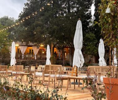 Terrasse en bois avec tables et parasols au camping Gallina Varja