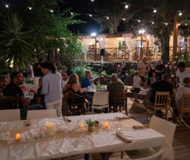 Terrasse extérieure avec tables et convives au CAMPING GALLINA VARJA