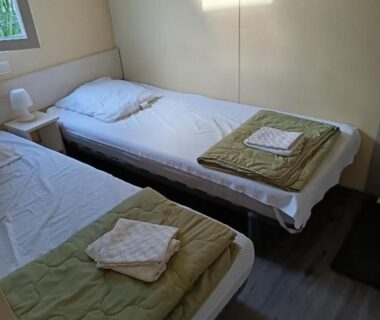 Intérieur chambre avec deux lits simples au Camping Le Clos du Thym
