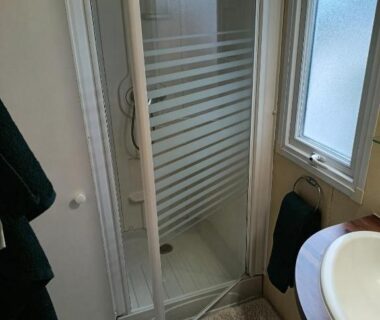 Salle de bain avec cabine de douche et lavabo au Camping Le Clos du Thym
