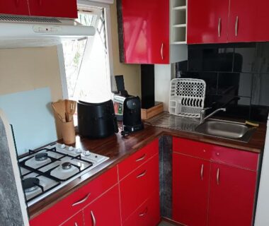 Cuisine équipée avec plaques gaz évier et rangements dans le mobil home du camping Le Clos du Thym