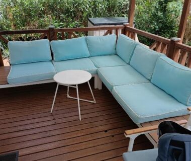 Terrasse en bois avec salon d'extérieur et table au Camping Le Clos du Thym