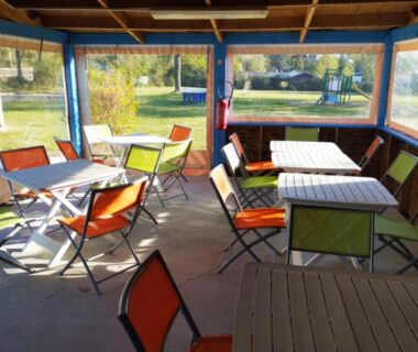 Terrasse couverte avec tables et chaises dans le camping Les Embruns 3*