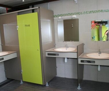 Bloc sanitaire avec lavabos et cabines au CAMPING LES EMBRUNS 3*