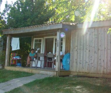 Terrasse ombragée avec chaises devant chalet au Camping Les Graves