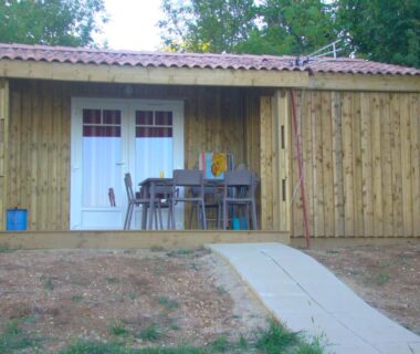 Terrasse avec table et chaises devant chalet au Camping Les Graves