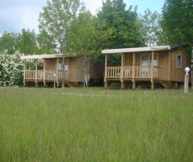 Prairie devant deux cabanes en bois au Camping Les Graves Cabane TITHOME