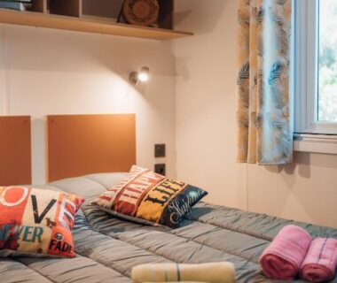 Chambre avec lits et serviettes dans un mobil-home au Camping Les Ourmes Hourtin