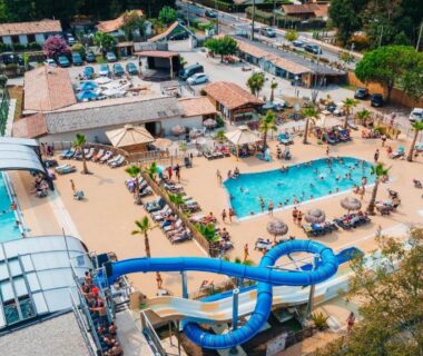 Espace aquatique avec toboggan, bassins et solarium au Camping Les Ourmes Hourtin