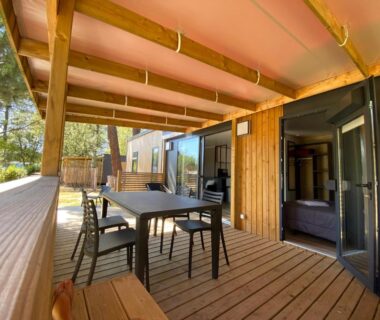 Terrasse couverte avec table et chaises du mobil-home au Camping Les Ourmes Hourtin