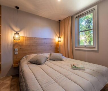 Intérieur chambre double avec lit et fenêtre au Camping Les Ourmes Hourtin