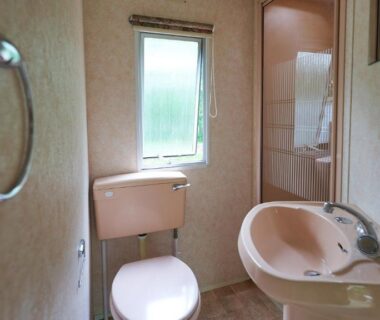 Salle de bain avec lavabo et WC dans le mobil home au Camping Les Paillotes