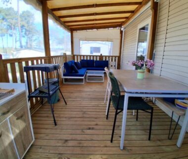 Terrasse couverte avec salon et coin repas au Camping Les EMBRUNS