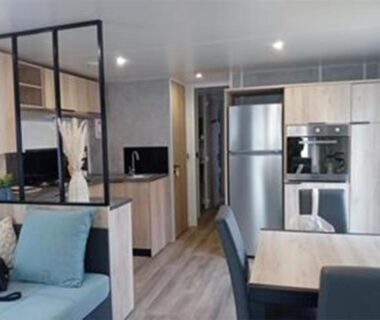 Intérieur avec cuisine ouverte et coin repas au CAMPING Les EMBRUNS - 4 ETOILES