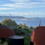 Terrasse avec deux chaises et table face à la mer au Camping Monte Ortu
