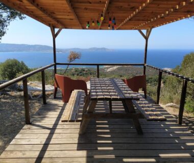 Terrasse vue mer avec table et chaises sous pergola au Camping Monte Ortu