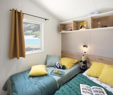 Chambre avec deux lits et fenêtre donnant sur la piscine au CAMPING PARADIS Domaine Oyat