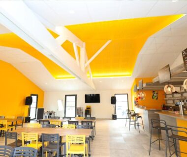 Salle de restaurant avec bar et tables au Camping Paradis Domaine Oyat