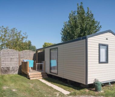 Mobil home sur pelouse avec terrasse en bois au Camping Paradis Domaine Oyat