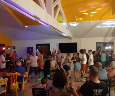 Salle d'animation avec danseurs et spectateurs au CAMPING PARADIS Domaine Oyat