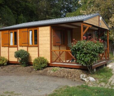 Allée et mobil-home en bois avec terrasse au Camping Plein Soleil