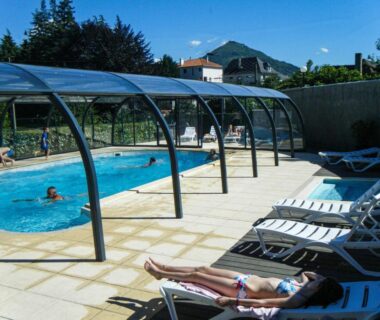 Piscine extérieure partiellement couverte avec transats au Camping Plein Soleil