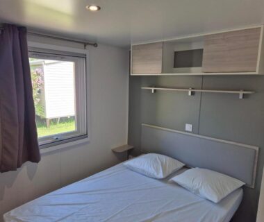 Chambre avec lit double et fenêtre dans mobile-home du CAMPING RÊVE DES ILES