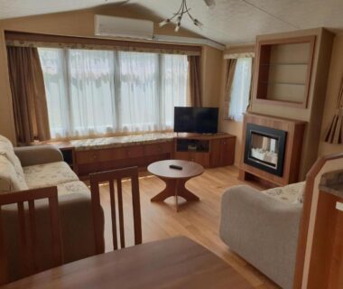 Salon avec canapés et cheminée au camping RÊVE DES ILES