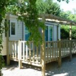 Terrasse en bois devant mobil-home ombragé au Camping U Sommalu