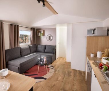 Séjour avec canapé d'angle et kitchenette dans le mobil-home du CAMPING U SOMMALU