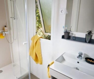 Salle de bain avec douche et serviettes jaunes au camping U Sommalu