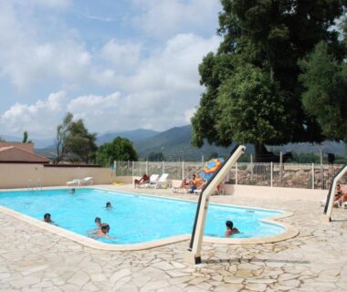 Piscine extérieure avec toboggan et transats au camping U Sommalu