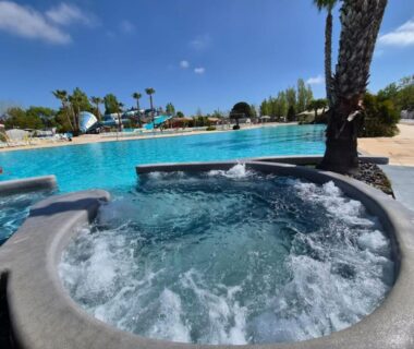 Piscine extérieure avec jacuzzi et palmiers dans le parc aquatique du CARABASSE DREAM