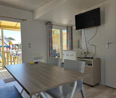 Intérieur coin repas et terrasse extérieure visible du CARNAC Mobil-Home Camping 4 étoiles