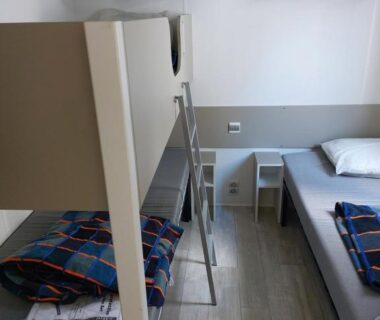 Intérieur chambre avec lits superposés et lit simple du CARNAC Mobil-Home Camping 4 étoiles