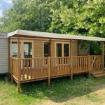 Mobil-home sur pelouse avec terrasse en bois au C&B Lodges