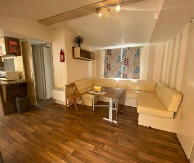 Salon avec banquette d'angle et cuisine ouverte dans C&B Lodges