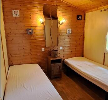 Chambre avec deux lits simples et lambris bois dans le chalet 35m2 climatisé 2 chambres vue mer