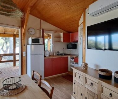 Intérieur avec coin repas cuisine et télévision dans le CHALET 35m2 climatisé 2 chambres vue mer