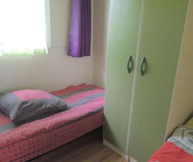 Chambre avec deux lits et armoire dans le CHALET 4 personnes maxi tout confort