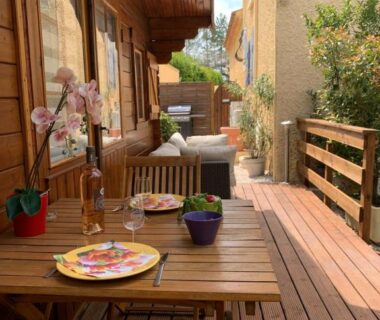 Terrasse en bois avec table plantes et coin salon du CHALET PISCINE JARDIN CLOTURE ANIMAUX Acceptés