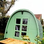 Dans le jardin cabane en bois avec petite terrasse à la Cabane Les Pourettes