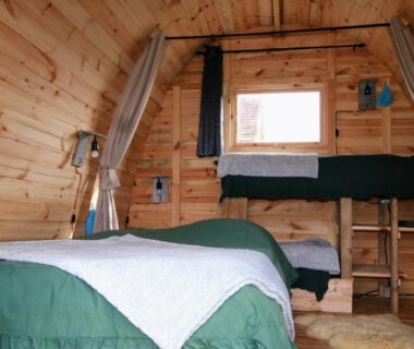 Intérieur en bois avec deux lits dans la cabane Les Pourettes