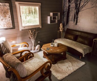 Salon cosy avec fauteuils canapé et table basse dans la Cabane insolite avec escape game