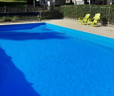 Piscine extérieure avec chaises longues à la Cabane randonneur au camping
