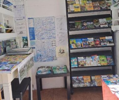 Intérieur du kiosque avec présentoirs de brochures dans la Cabane randonneur au camping