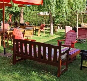 Jardin ombragé avec bancs parasols et fleurs près de la Cabane randonneur au camping